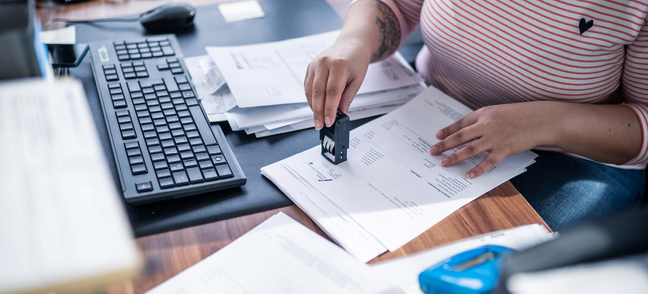 Frau am Computer unterzeichnet Unterlagen
