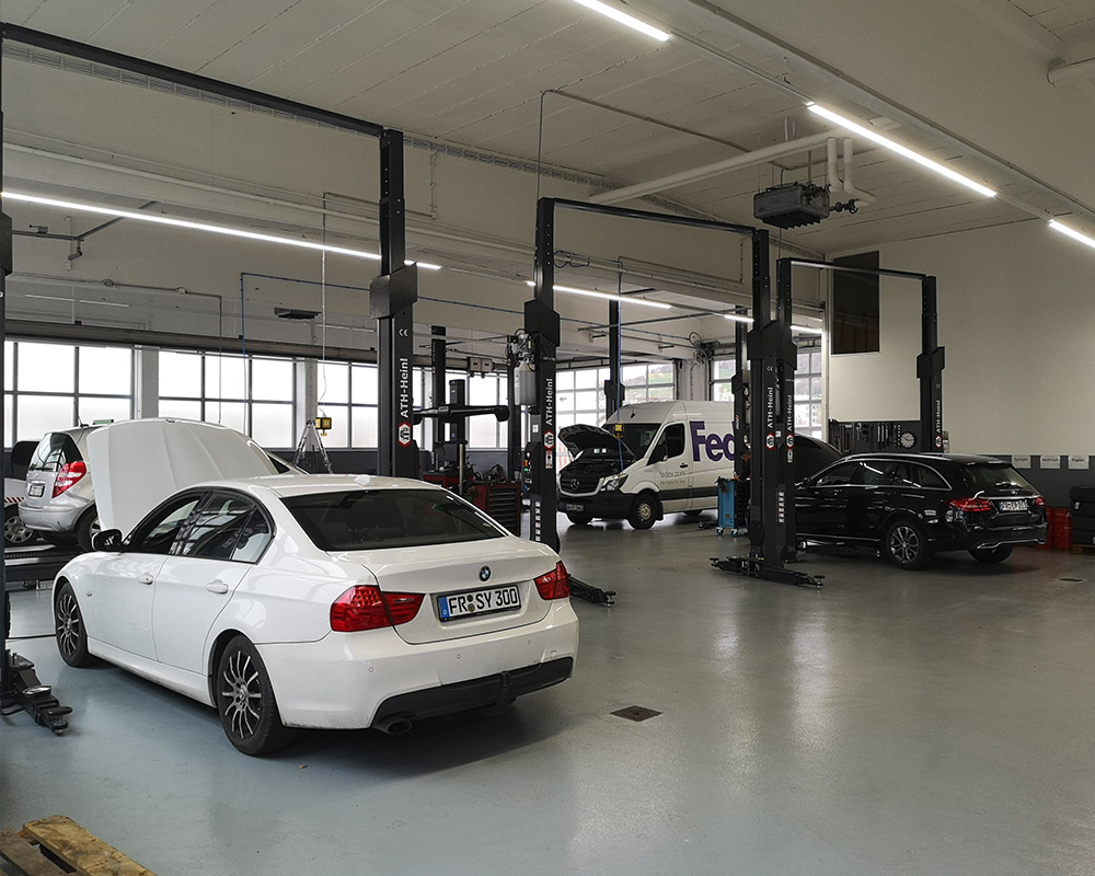 zu sehen ist die Werkstatt mit einem weißen BMW